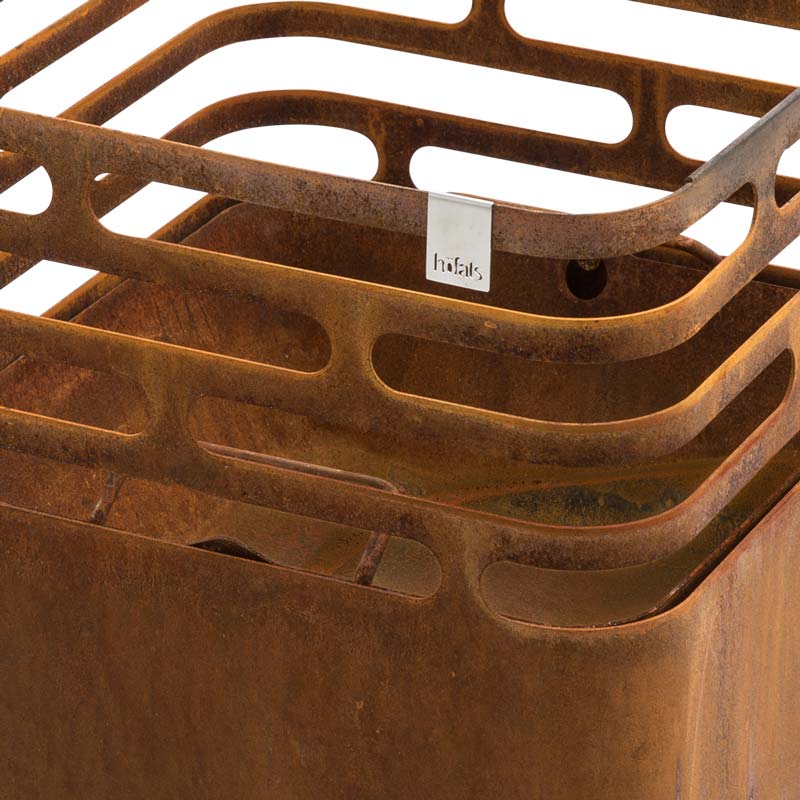 This image shows a rusty metal container with a tag on it, with the CUBE Ash Tray Stainless Steel.