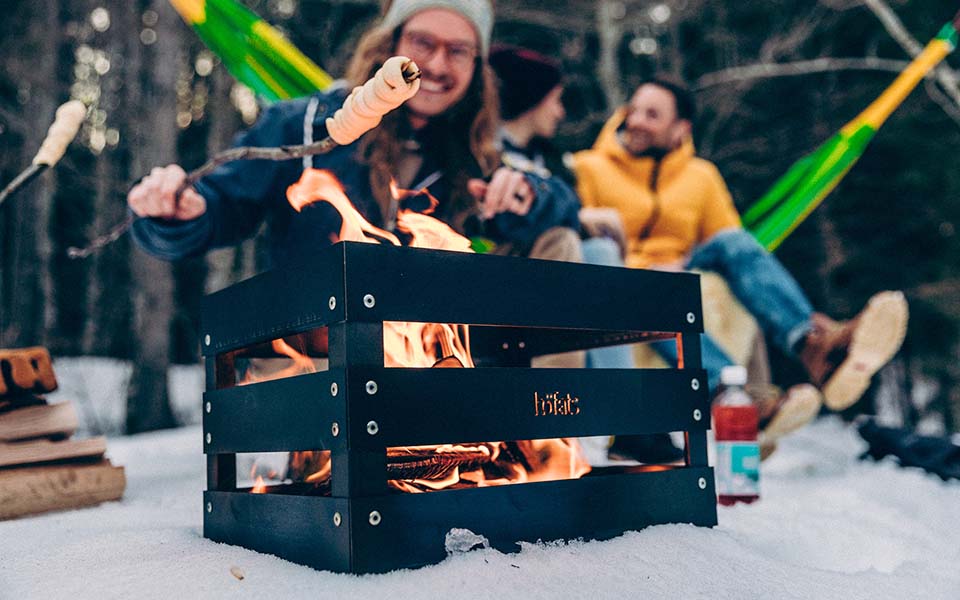 A view of a man and woman sitting around a campfire, with the Atmospheric image Christmas for Console.