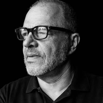 a man with glasses and a black shirt.