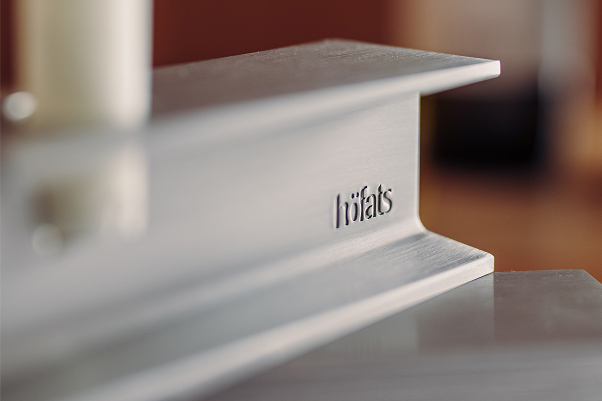 This image shows a close up of a white table with a candle, with the HENRY METAL I Candleholder silver.