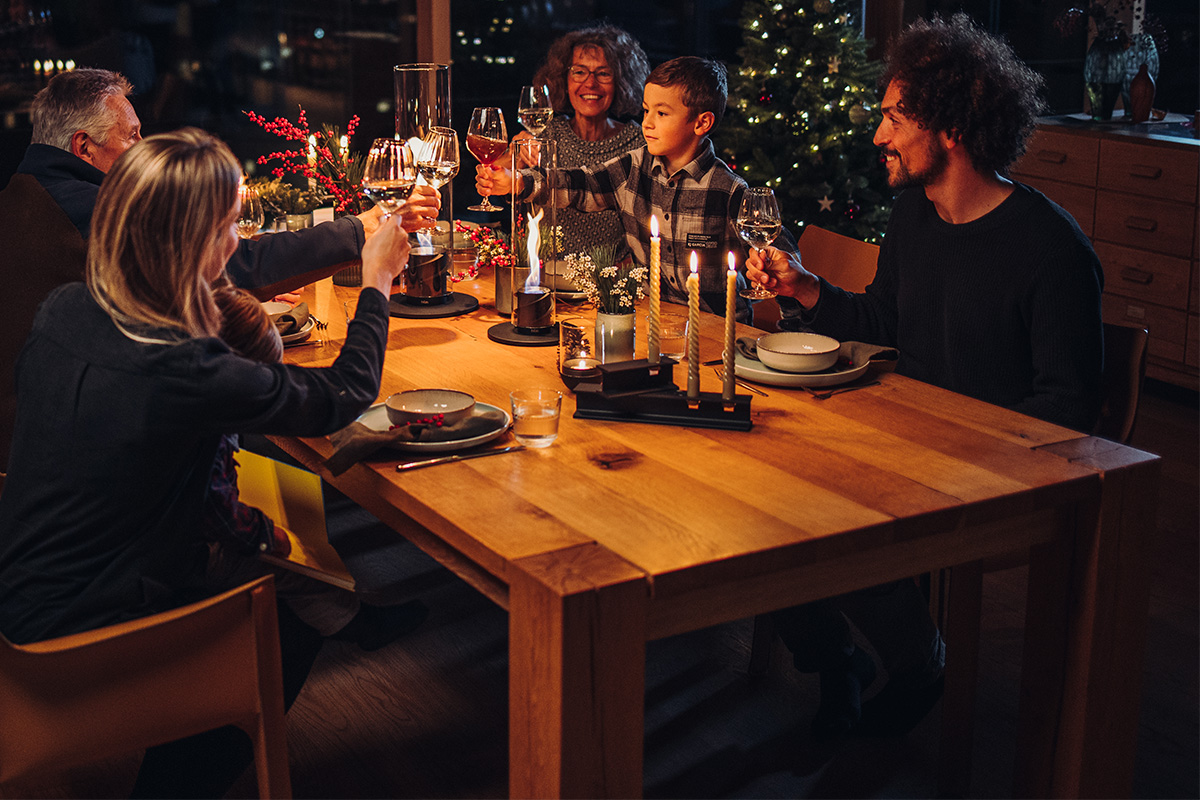 HENRY METAL I Candleholder black The photo presents a group of people sitting around a table, with the HENRY METAL II Candleholder black.