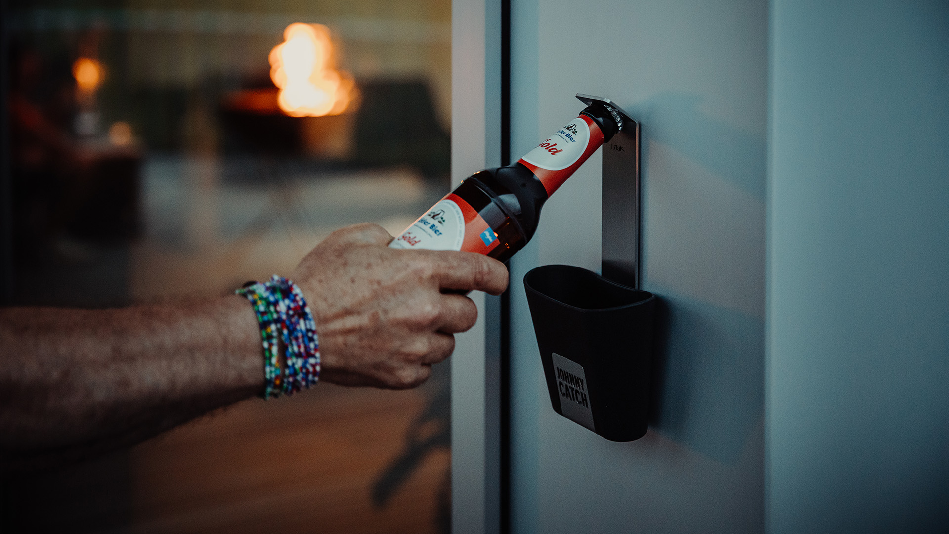 Scene showing a person is opening a buttle with a bottleopener, where the Johnny Catch Cup stands out for its practical elegance.