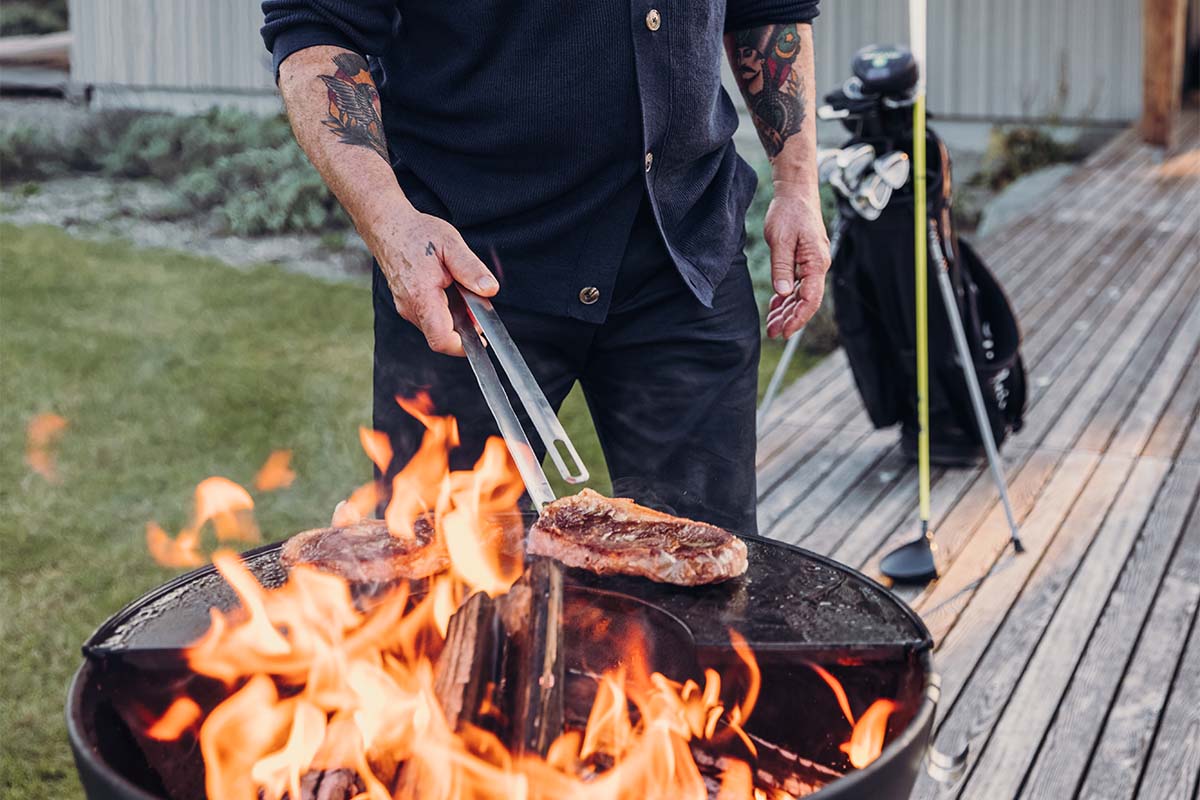 Barbecue Tongs This image shows a man cooking steak on a grill