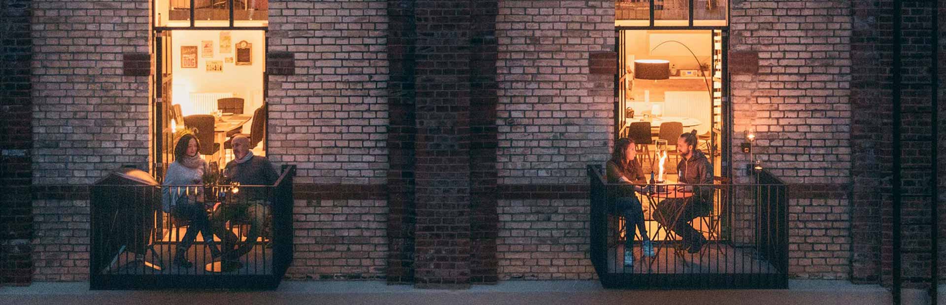 This image shows people sit on the balcony of a building at night, with the CONE.