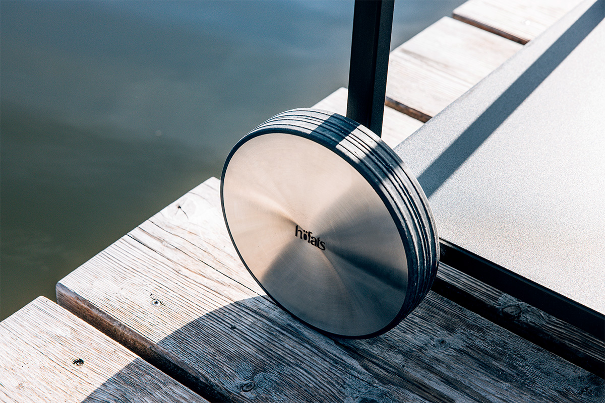 Depicted here is a metal disc on a wooden dock, with the FIRE KITCHEN Wheel Set (2 pcs).
