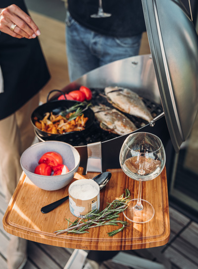 The 010201 CONE Board integrates seamlessly into the setting, where a person holding a plate of food on a table.