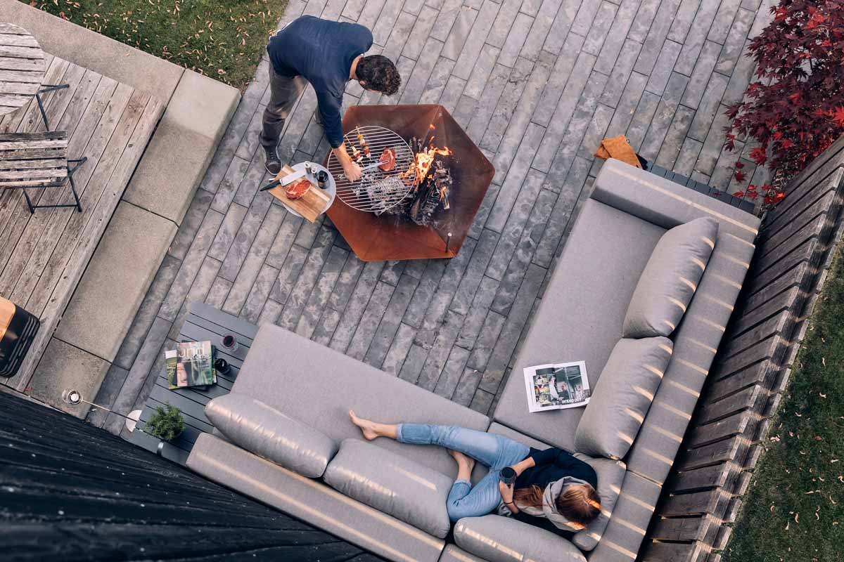 TRIPLE Grid 55 The Triple Grid 55 integrates seamlessly into the setting, where a couple sitting on a patio with a fire pit.