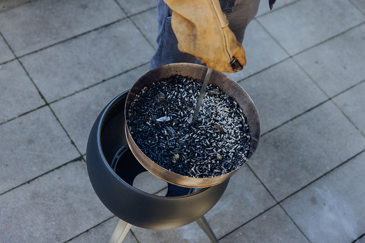 The 00832 Moon 45 Elevation for Ashtray is shown as a person holding a bowl of burnt wooden pellets, creating a stylish and accessible visual.