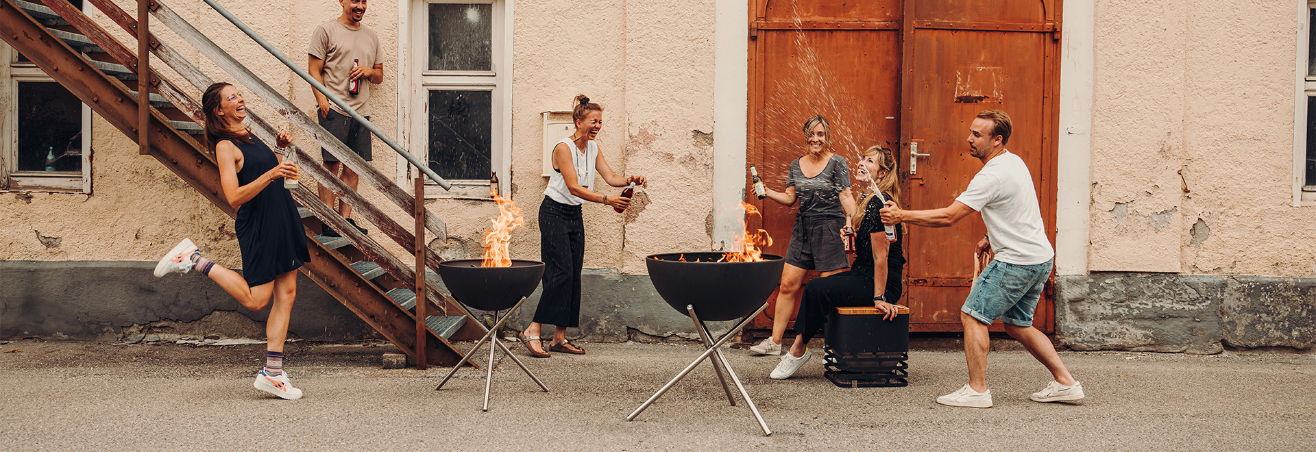 a group of people standing around a fire pit