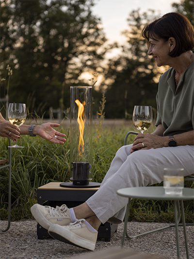 An inviting scene with woman sitting on a chair next to a SPIN Tablefire