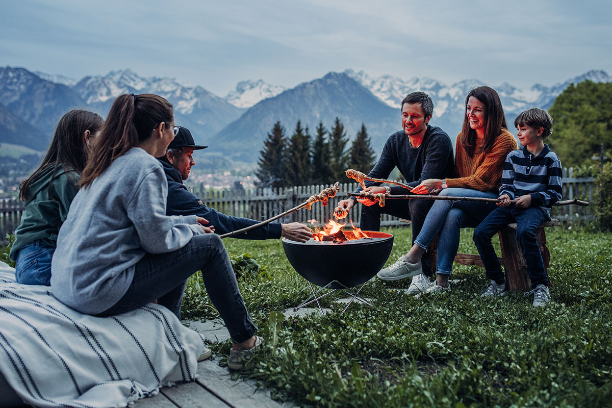 Depicted here is a group of people sitting around a fire pit, with the BOWL 57 Fire Set flex.