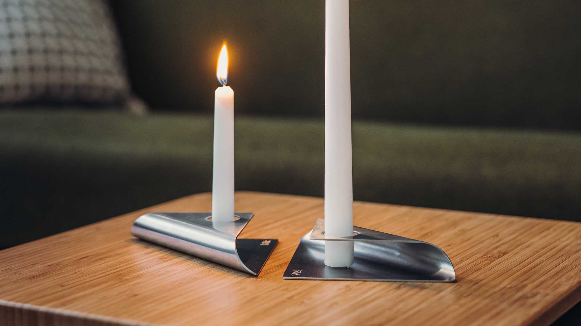 The photo presents a white candle on a wooden table, with the SQUARE CANDLE (Matrix - Parent).