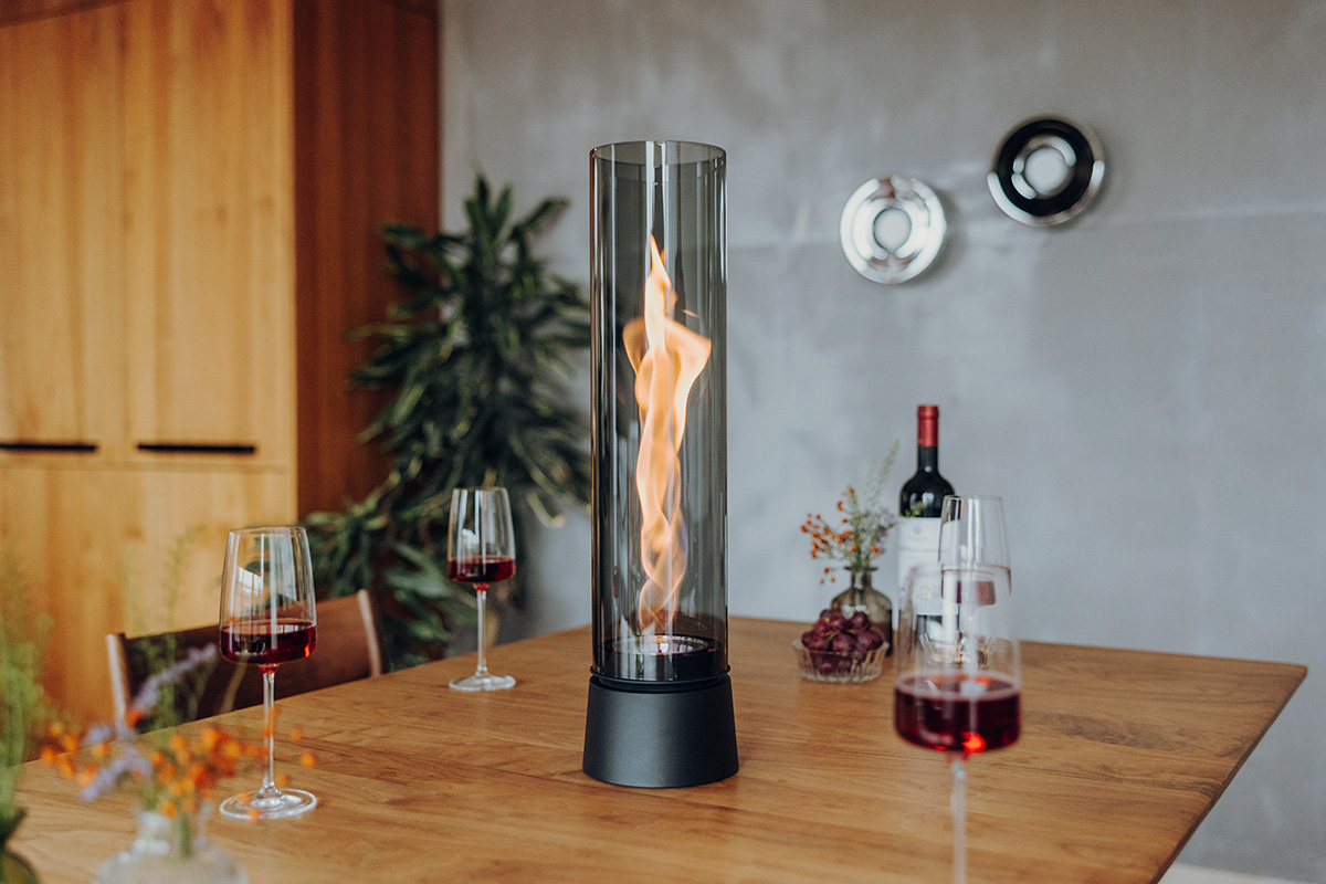 SPIN air 1200 Tabletop Fireplace all black SPIN air all black auf einem Tisch mit Wein