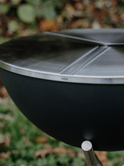 a black grill with a silver metal lid