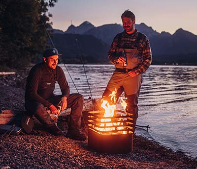 two men sitting around a campfire.