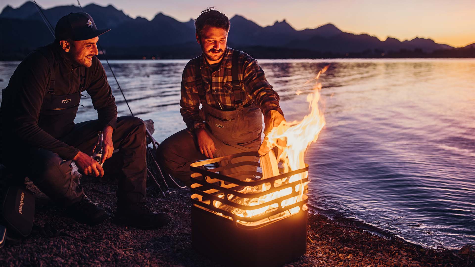 Two men sitting around a campfire the Cube Firebasket rusty complements the moment with its thoughtful design.
