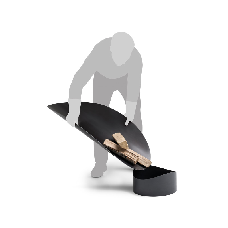 This image shows a man is standing on a black object, with the ELLIPSE Fire Bowl.