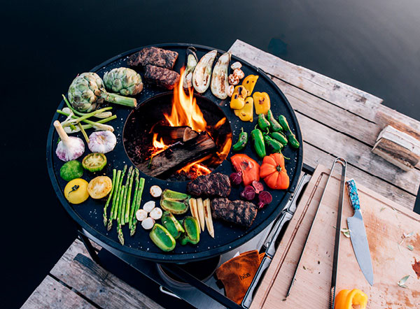 a fire pit with a grill on a dock.