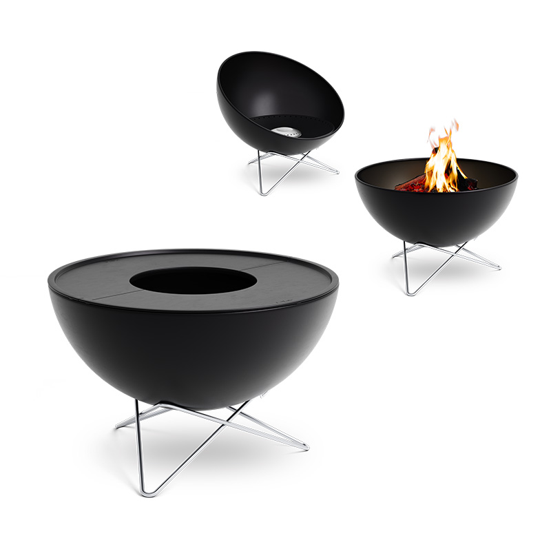Depicted here is a black fire pit with a flame in it, with the BOWL 57 Plancha BBQ Set low.
