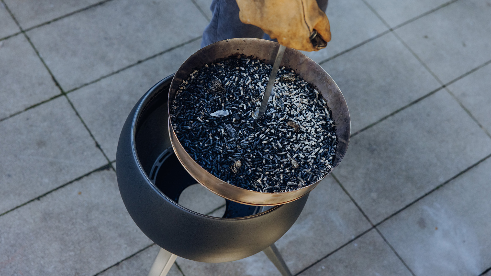 The 00832 Moon 45 Elevation for Ashtray is shown as a person holding a bowl of burnt wooden pellets, creating a stylish and accessible visual.