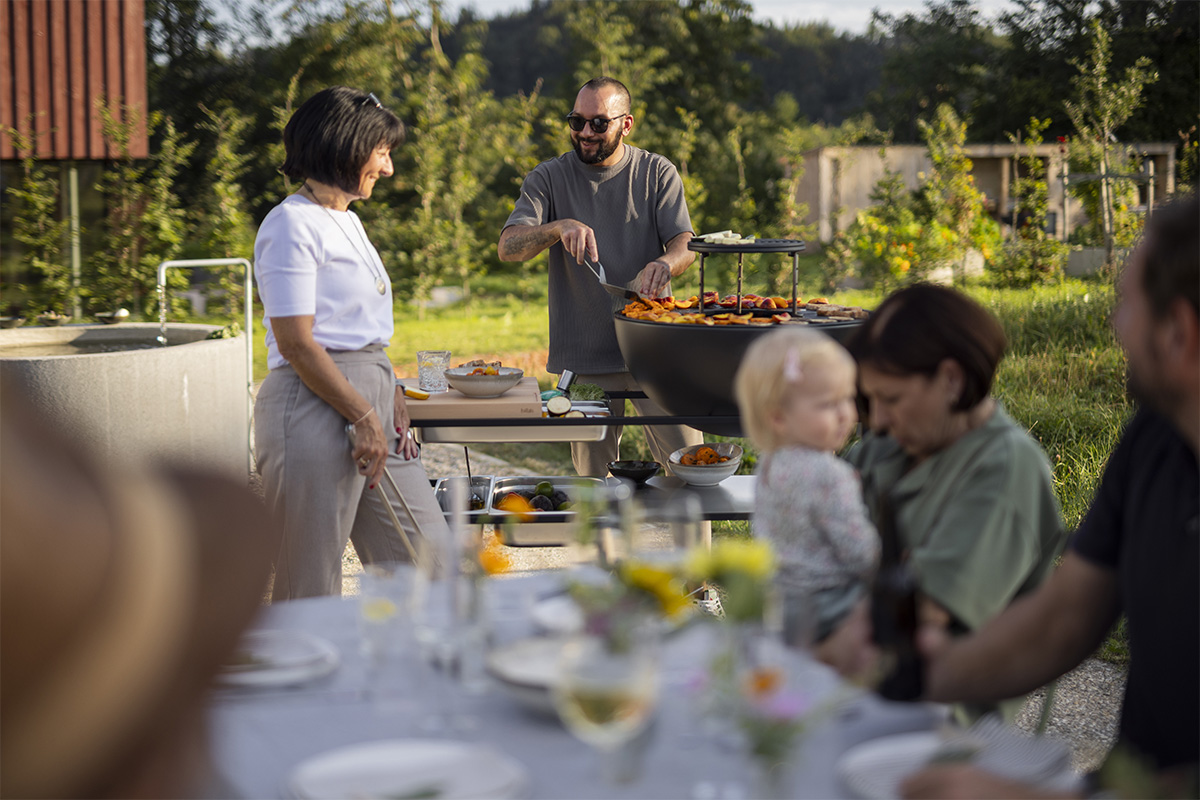 The 00740 Fire Kitchen Bowl 70 Plancha BBQ Set is shown as a group of people sitting around a table, creating a stylish and accessible visual.