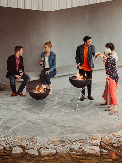 a group of people sitting around a fire pit.
