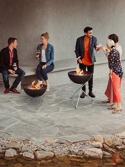 a group of people sitting around a fire pit.
