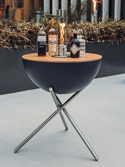 An image showing a fire pit with a bottle of alcohol on it, with the CUBE Board.