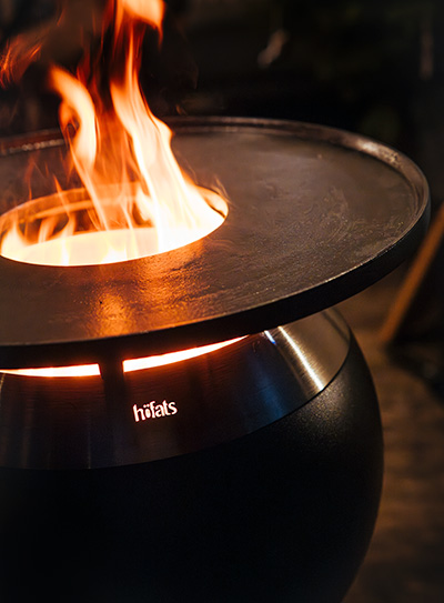A depiction of a fire pit, featuring the Moon Plancha as a central and purposeful element.