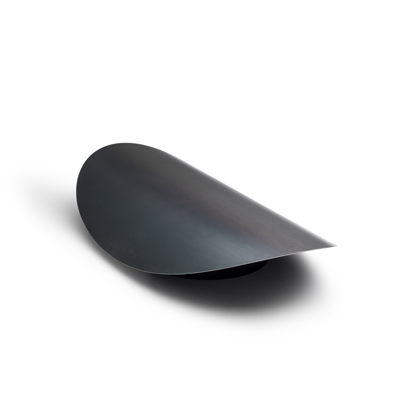 A view of a black sheet of metal on a white background, with the ELLIPSE Fire Bowl.