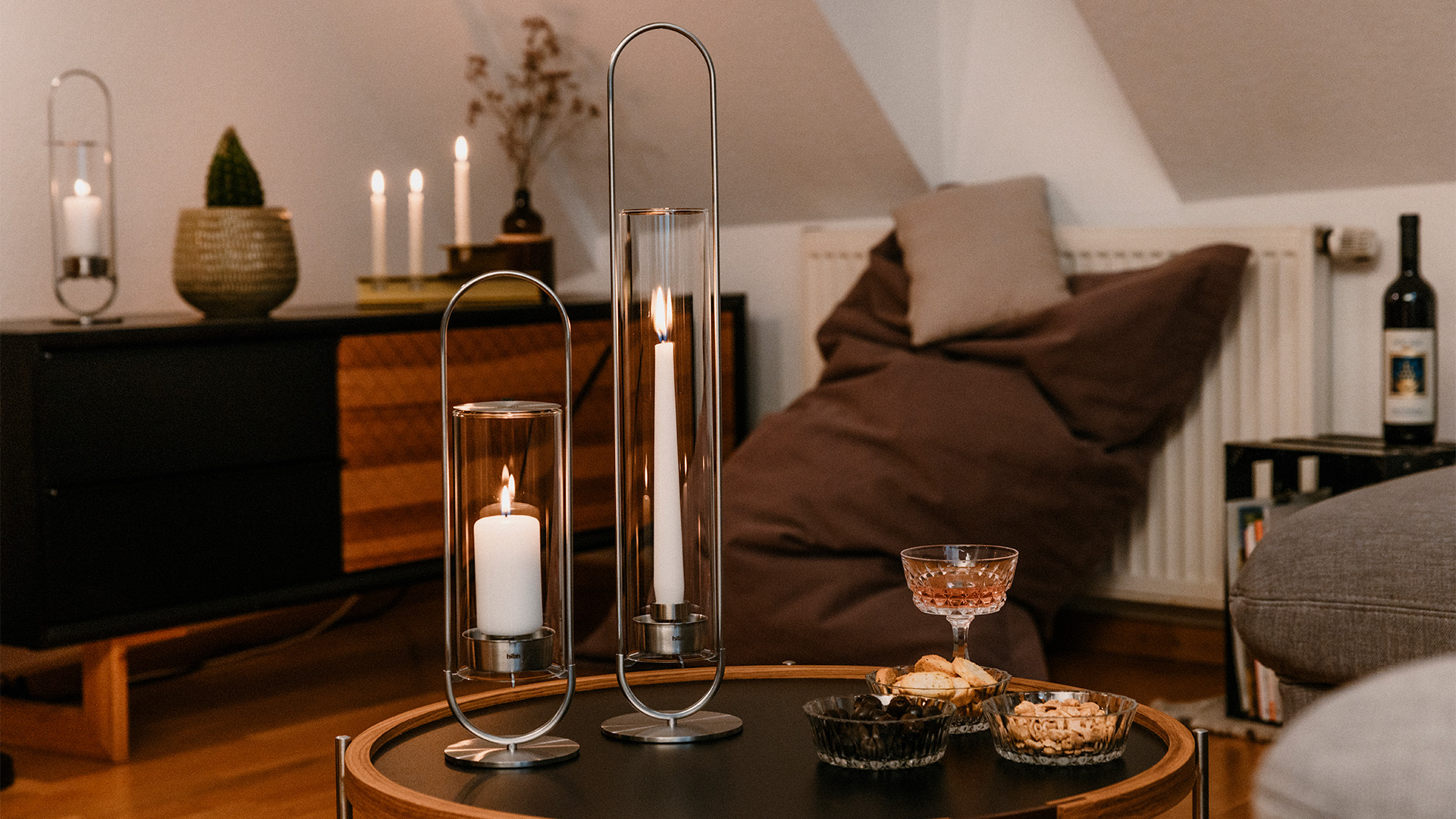 An image showing a table with a candle and a glass on it, with the OVAL CANDLE 55 Glass Cylinder.