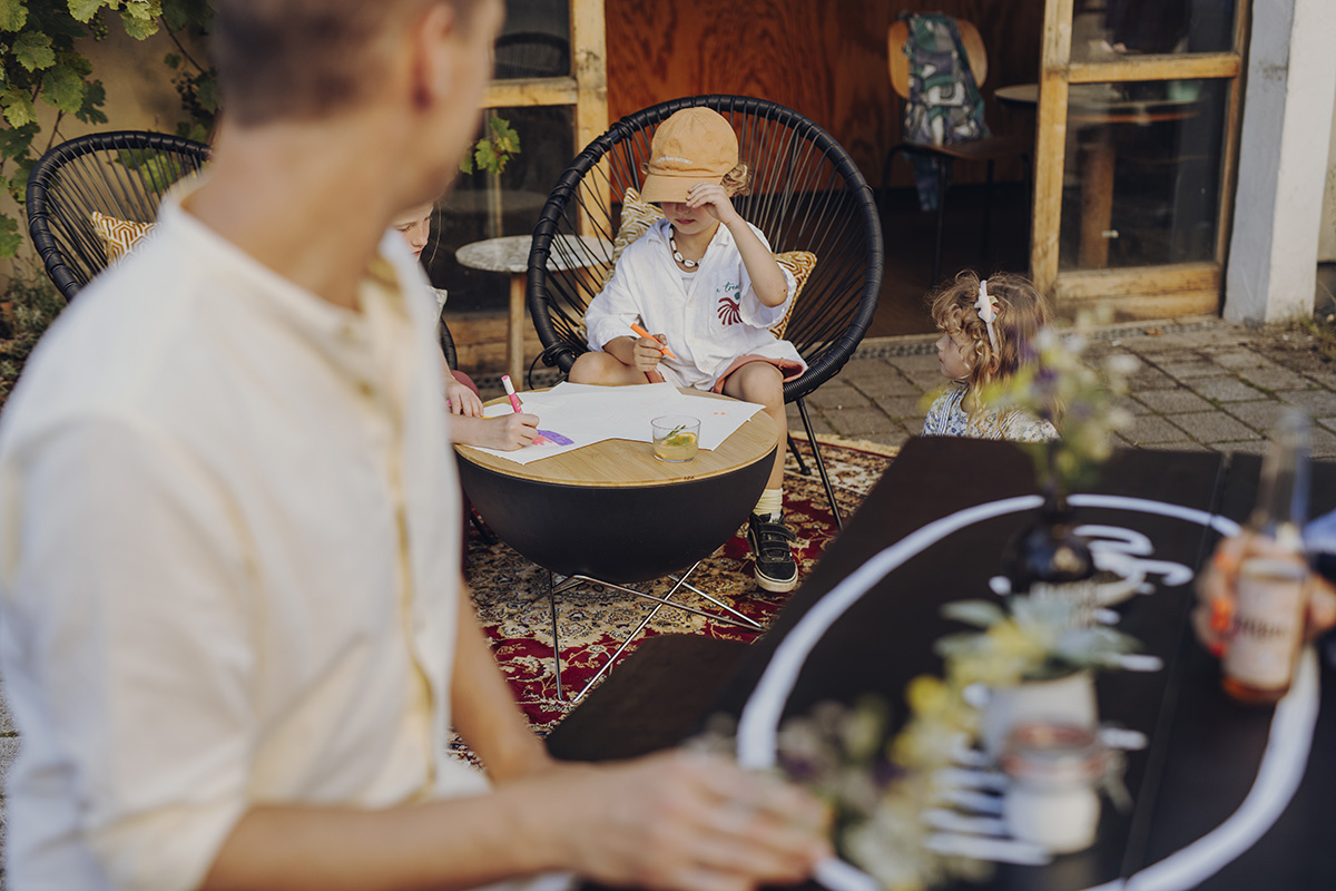 A man sitting in a chair, with the 00569 BOWL 57 Board adding a functional and elegant touch to the scene.