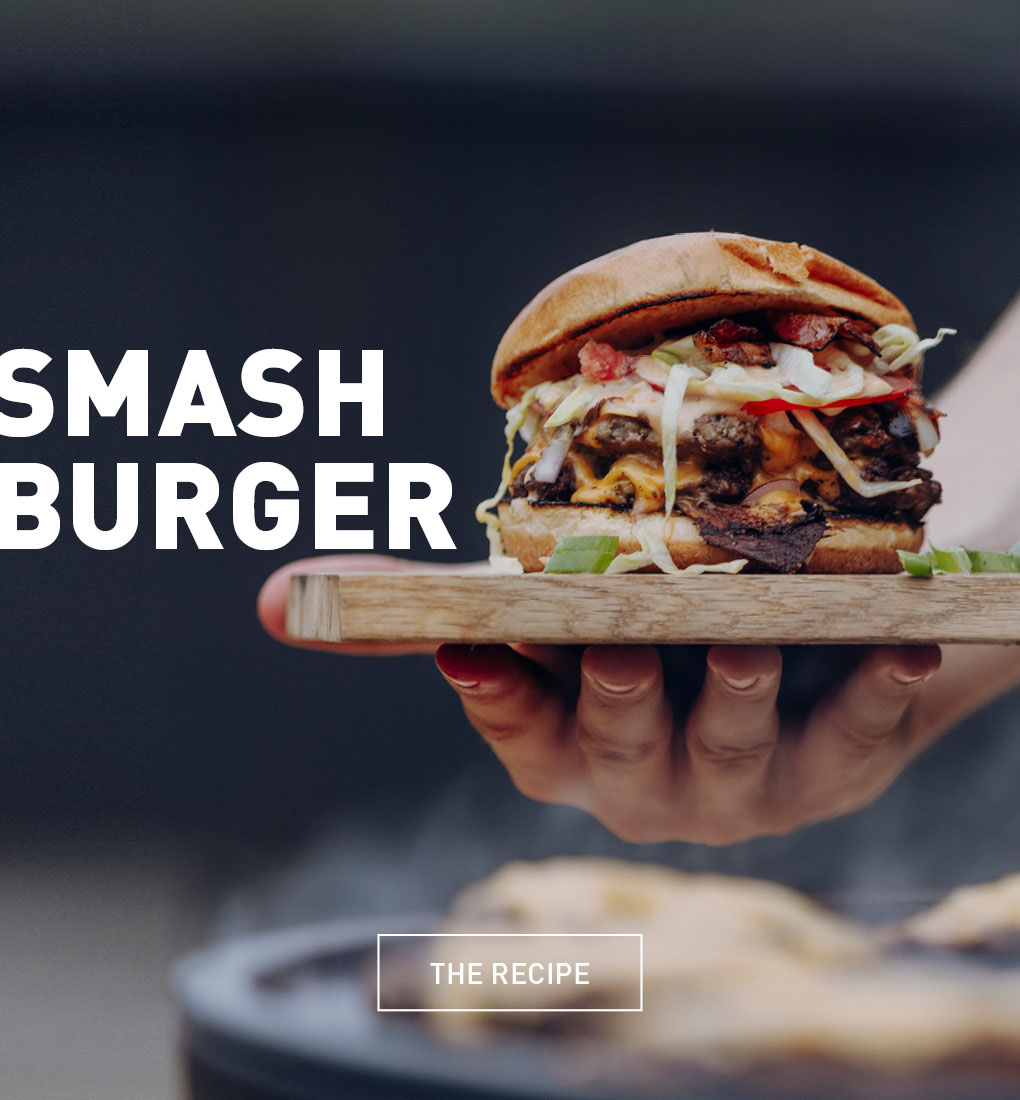 a person holding a hamburger in their hand.