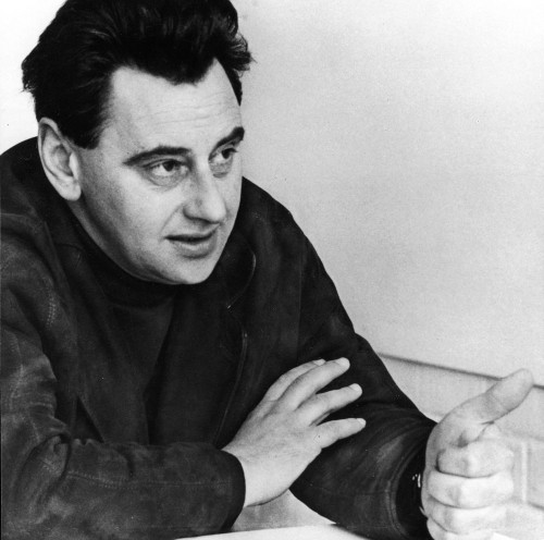 a man sitting at a table with his hand on his chin.