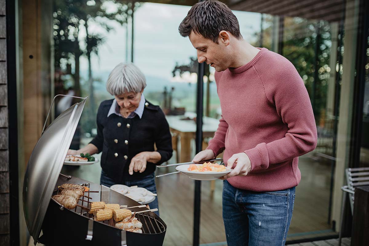 CONE Charcoal Grill An image showing a man and woman grilling food on a grill, with the CONE Charcoal Grill.
