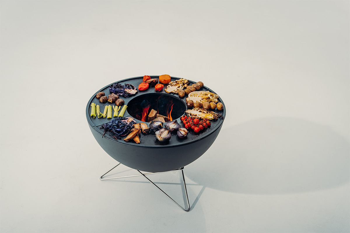 BOWL 70 Fire Bowl with star stand The Bowl 70 BBQ Set low integrates seamlessly into the setting, with a black bowl with planchas and grilled vegetables