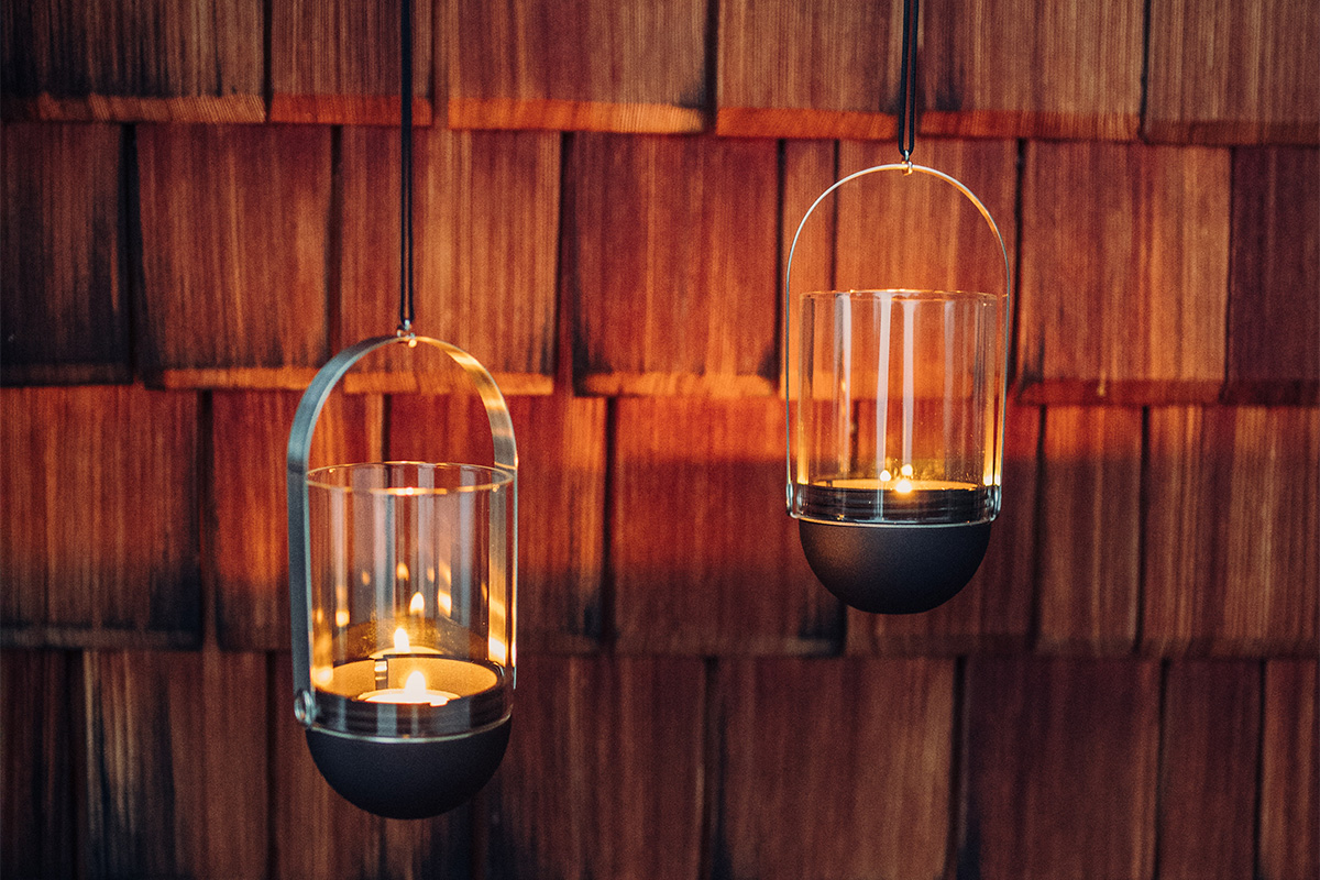 The Gravity Candle Hanging System is shown as two candles are lit on a table, creating a stylish and accessible visual.