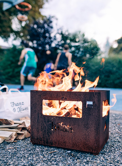 An inviting scene with a group of people playing a game of basketball, highlighted by the presence of the Beer Box Firebasket
