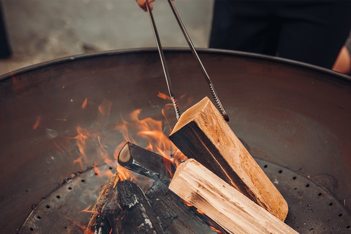 Fire Tongs A view of a person is cooking something on a fire, with the Fire Tongs.