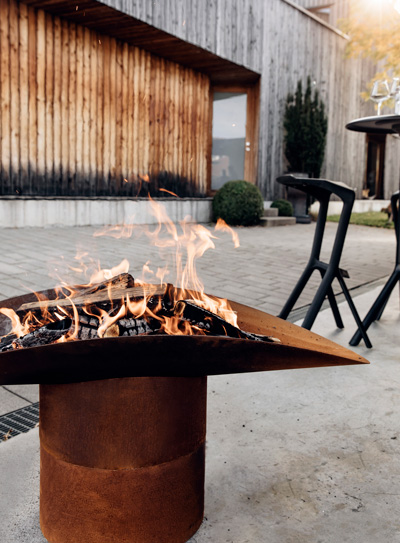 A view of a fire pit with a fire in it, with the ELLIPSE Fire Bowl.