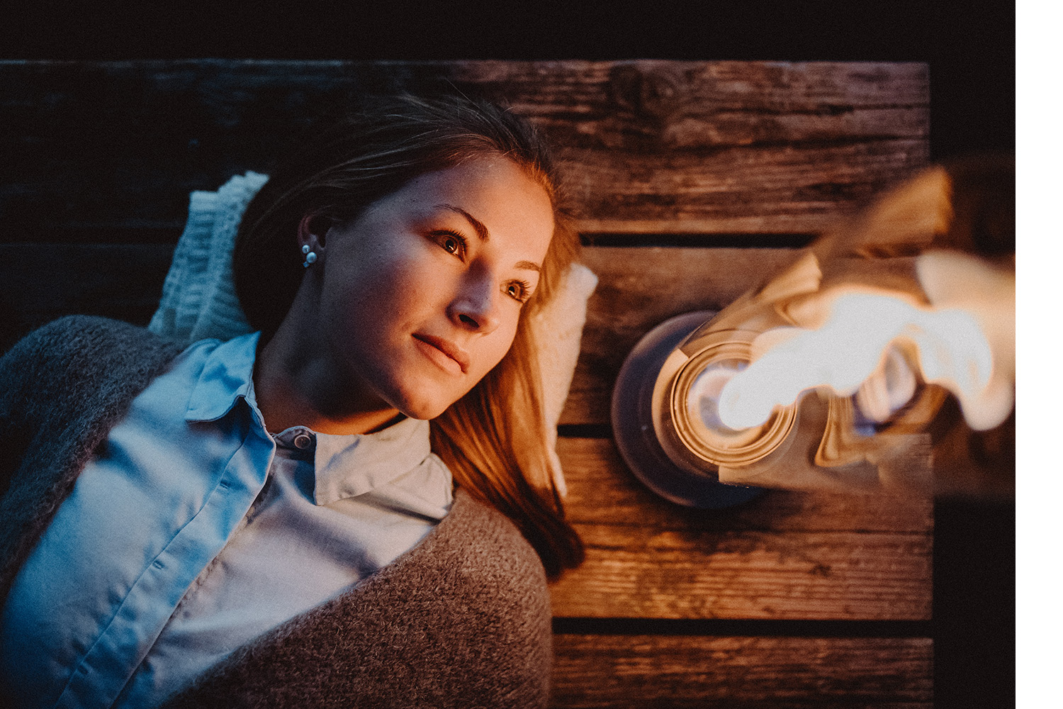 A woman laying on her back, looking at the fire of a SPIN Tablefire