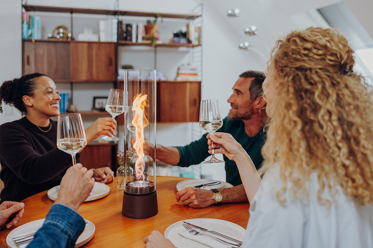 SPIN air 1200 rostbraun an einem runden Tisch mit Tellern und Menschen welche Wein trinken