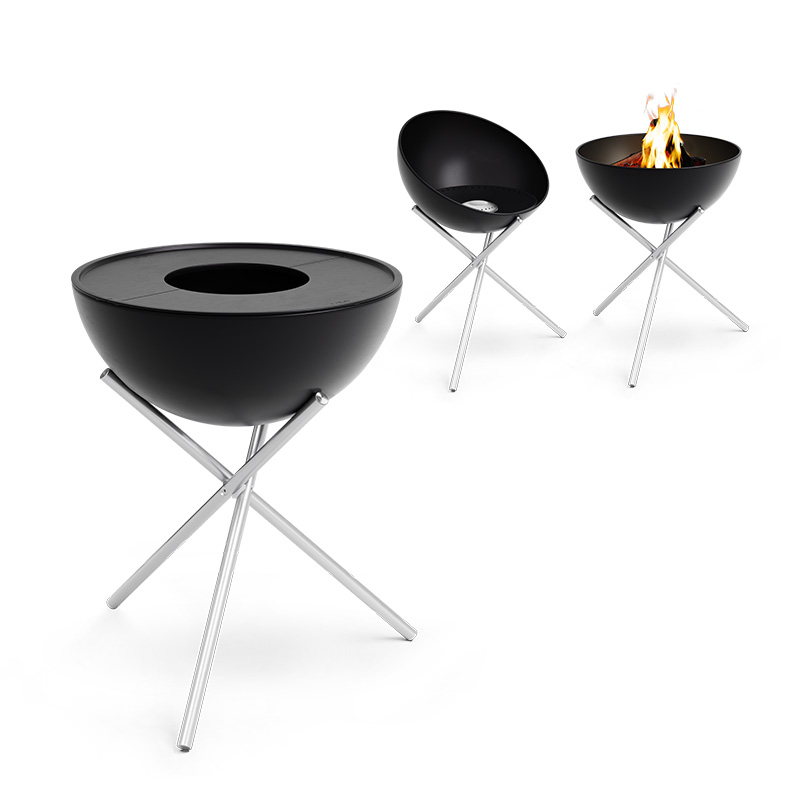 BOWL 57 Plancha BBQ Set high Two black fire bowls with a fire in the middle, enriched by the presence of the 00487 BOWL Pancha BBQ Set high, which merges design with utility.