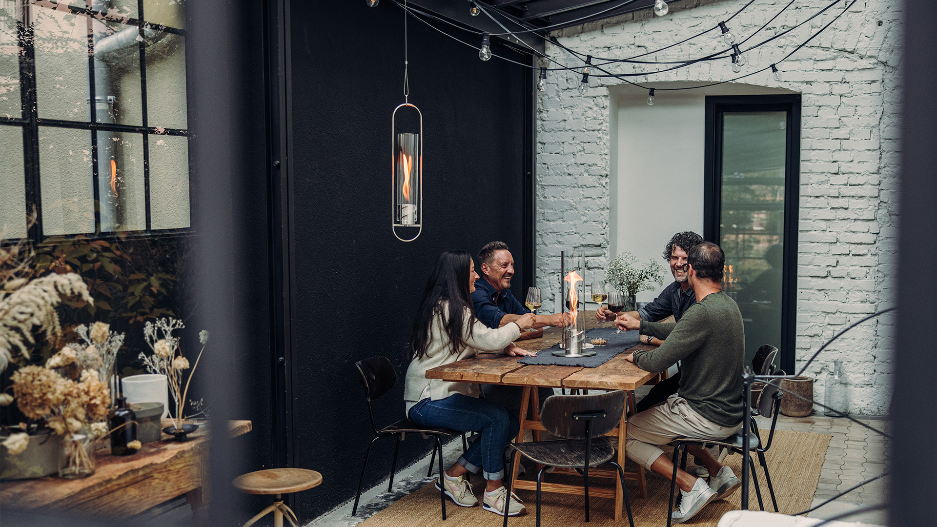 The Spin 900 Hanging Fire is shown as a couple sitting at a table in a restaurant, creating a stylish and accessible visual.