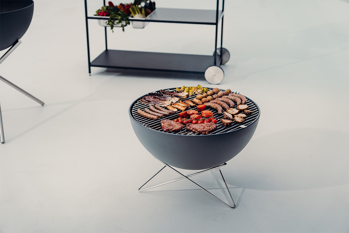 BOWL 70 Fire Bowl with star stand a grill with meat and vegetables on it with the refined touch of the 00257 Bowl 70 with starstand