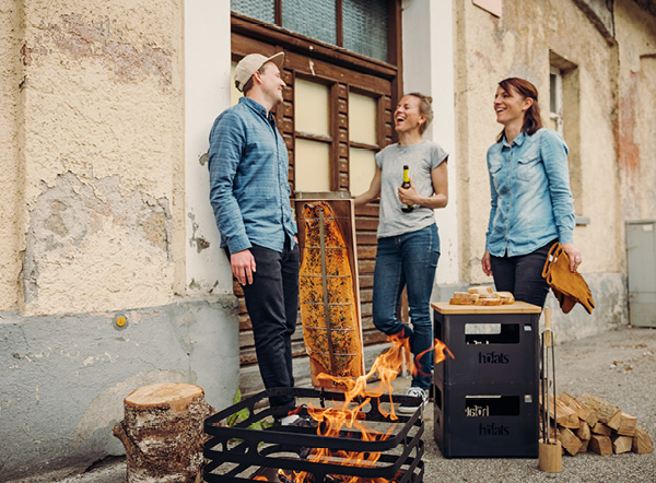 Flame-Grilled Salmon Recipes a couple standing next to a fire pit.