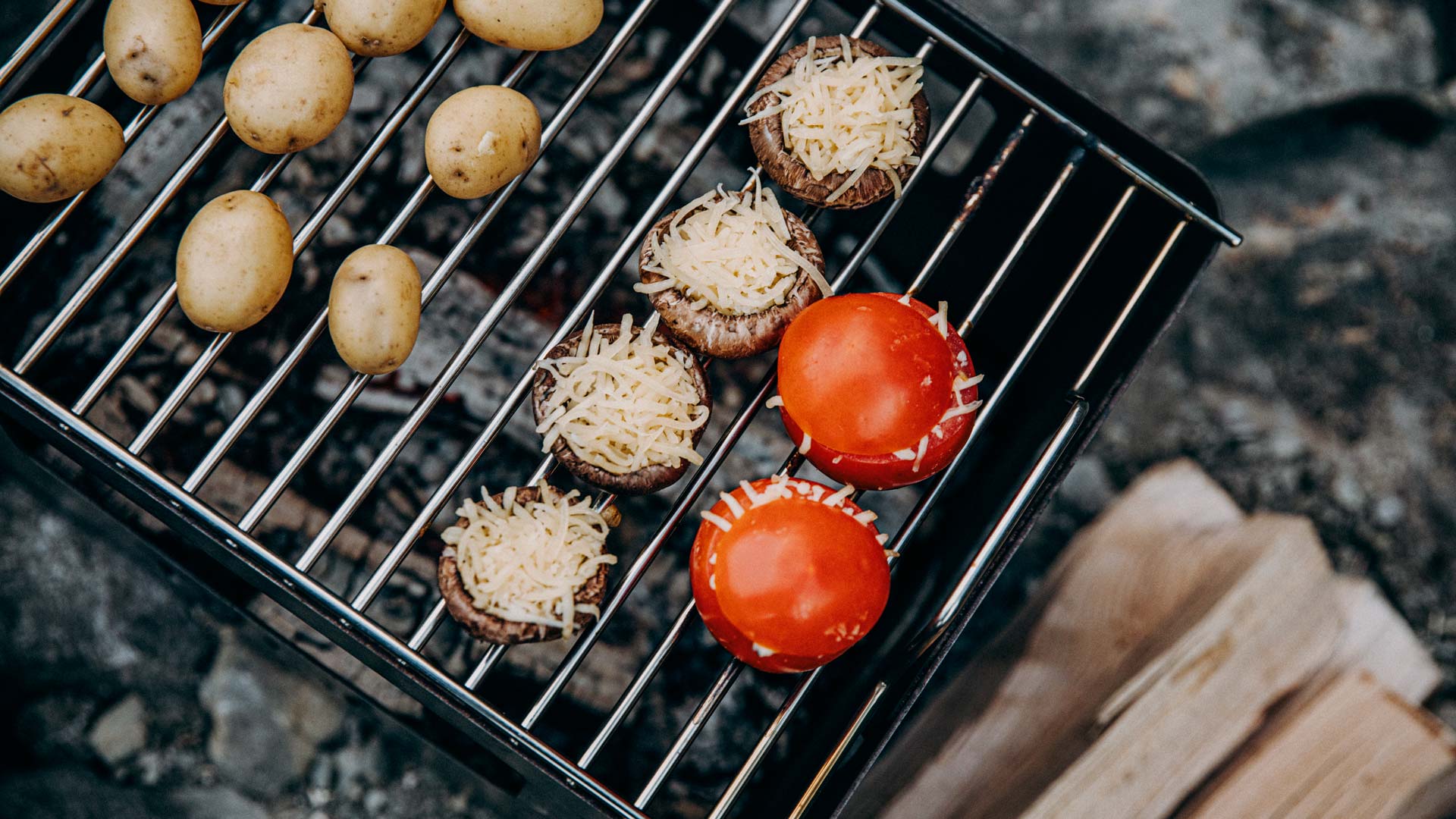 Illustrated is a grill with potatoes and tomatoes on it, with the BEER BOX Grid.