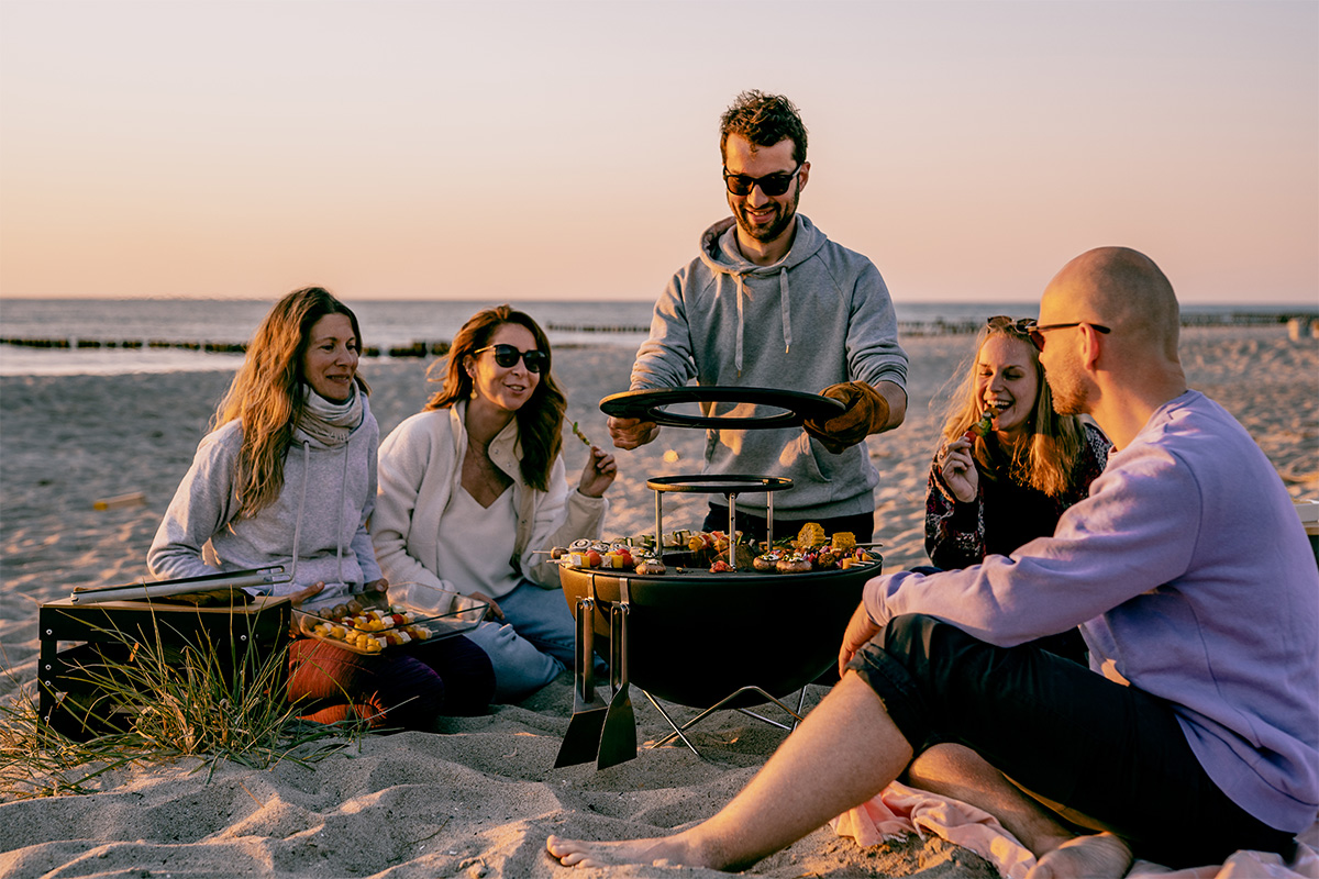 BOWL 57 Warming Ring Depicted here is a group of people sitting on a beach, with the BOWL 57 Warming Ring.