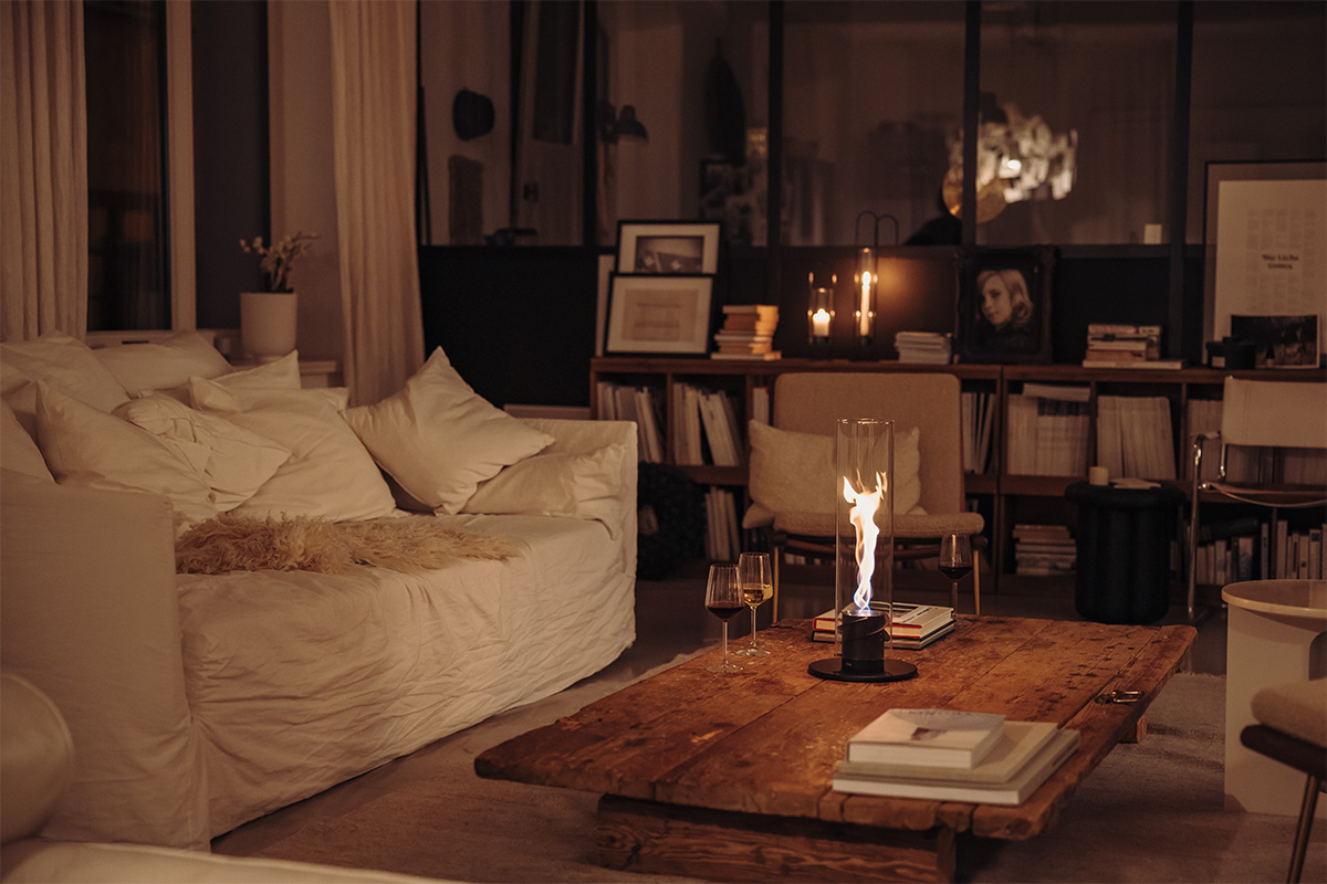 SPIN 900 Tabletop Fireplace black A living room with a couch, coffee table, and a Tablefire. the 00700 Spin 1200 Tablefire black complements the moment with its thoughtful design.