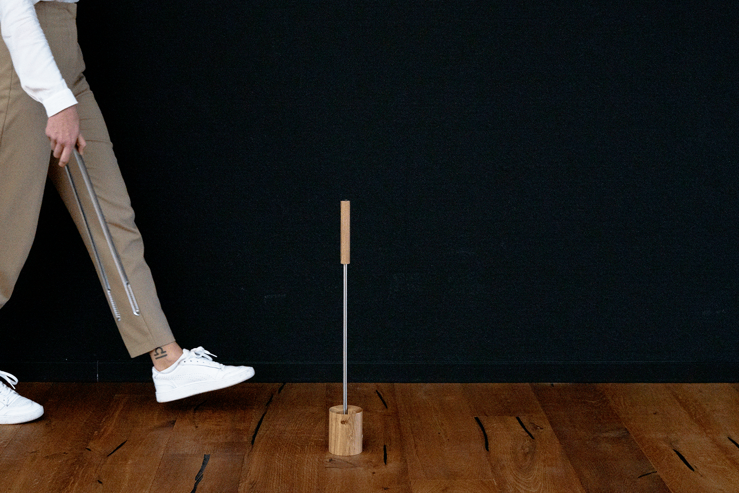 a man is standing on a wooden floor with a stick.
